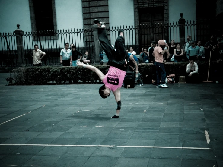 a dancer performs tricks in front of a crowd of people