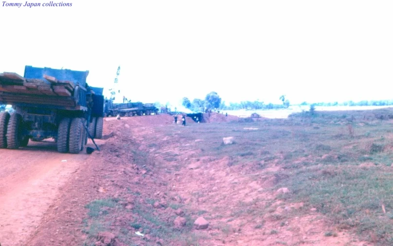 a military truck hauling metal equipment near a field