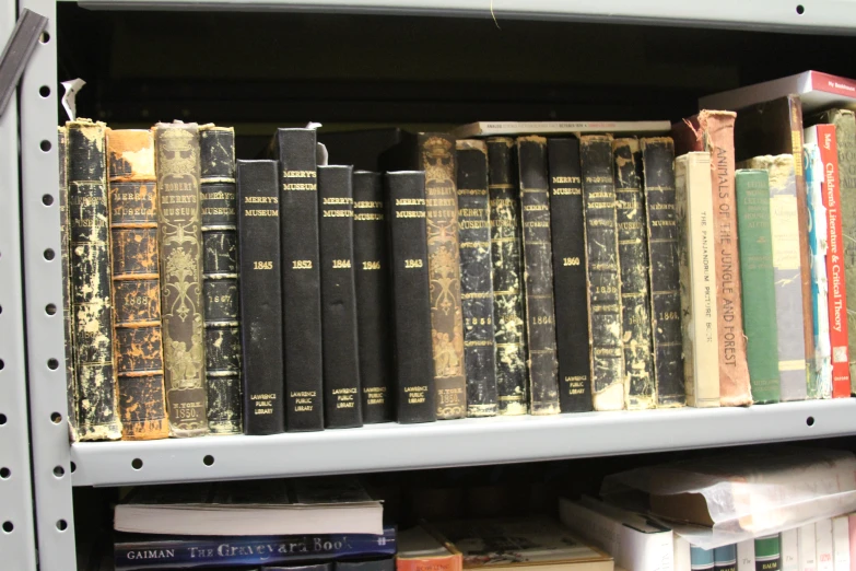 a row of books sitting on top of a white shelf