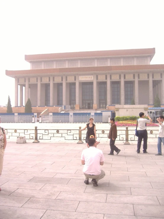 people looking at soing while two of them is sitting on the ground