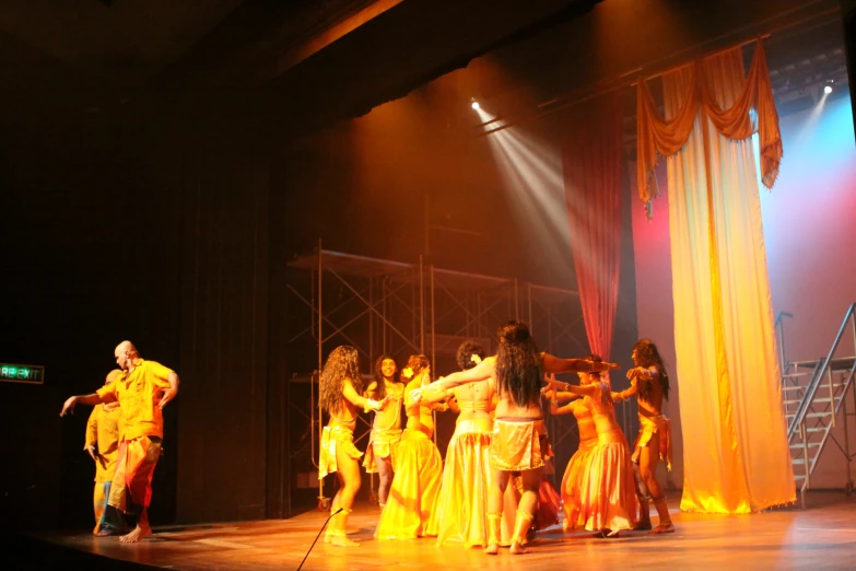 a group of people in costumes dancing on stage