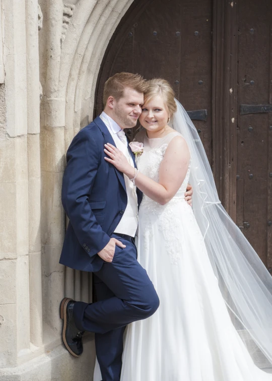 bride and groom at doorway of building in urban setting