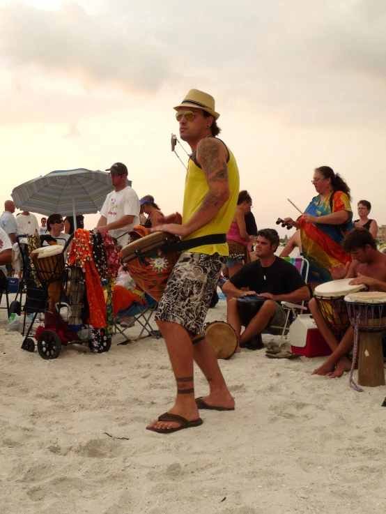 an african man playing the drums in front of a crowd of people