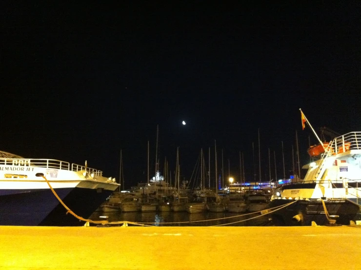 two large boats sitting in a harbor at night