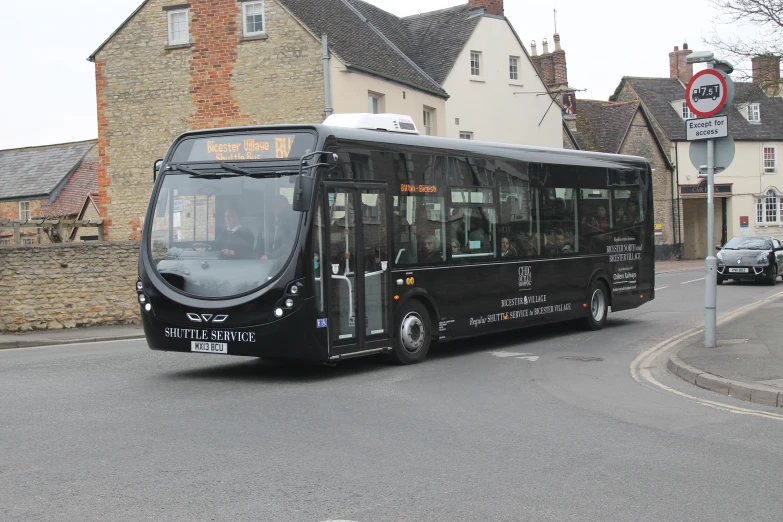 black passenger bus parked on side of street next to brick building