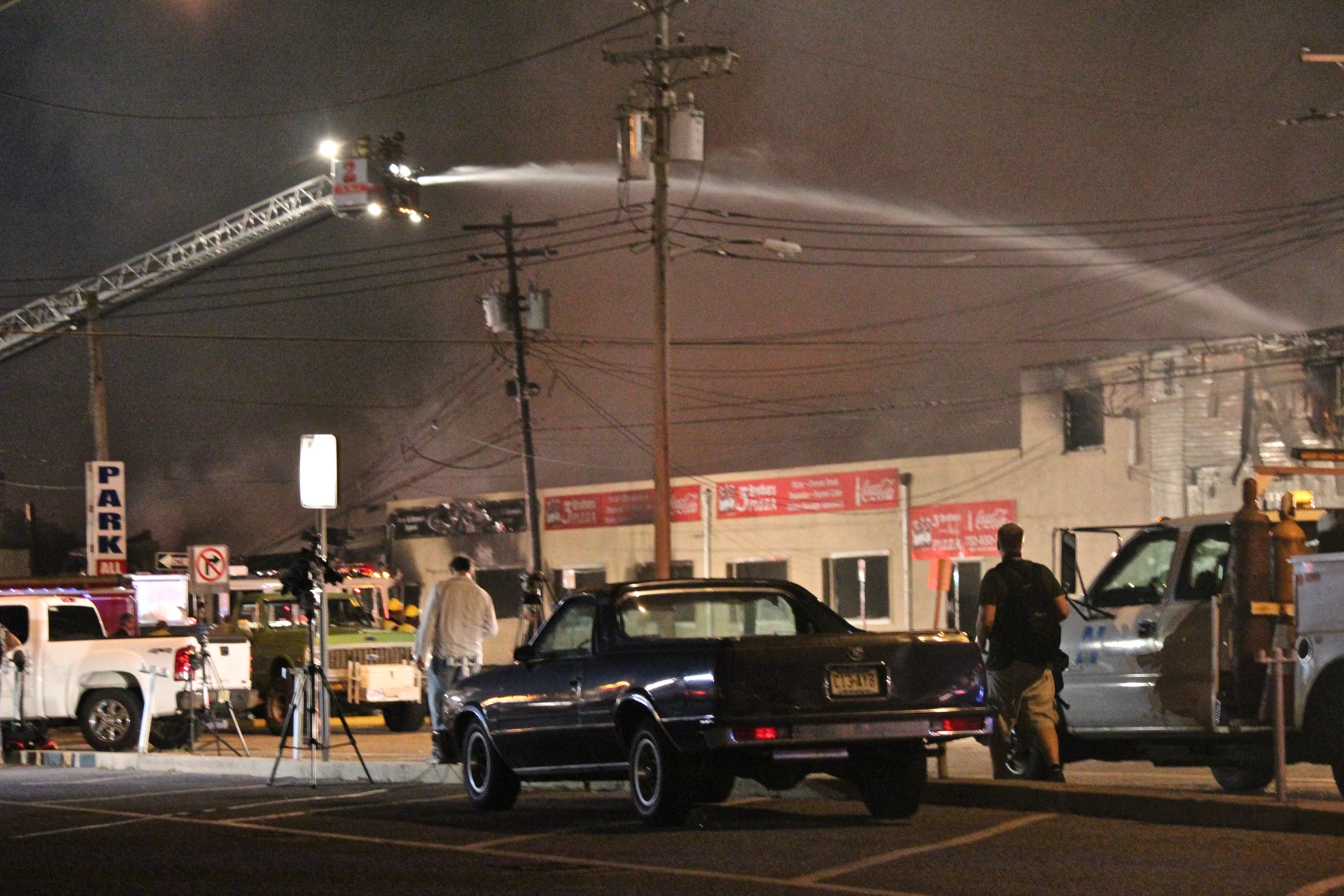 a group of people standing next to two trucks at a fire station