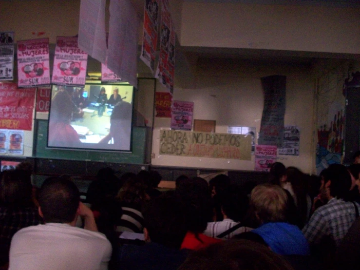 a large group of people watching a tv