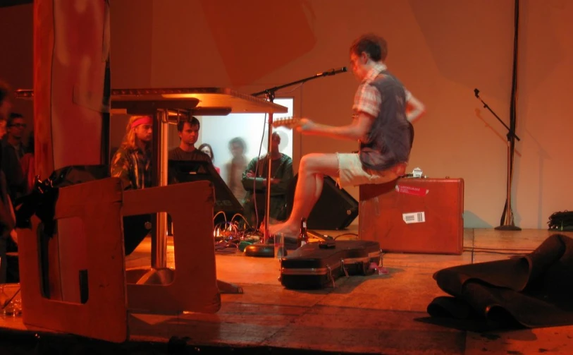 people on a stage with musical instruments and a man on stage