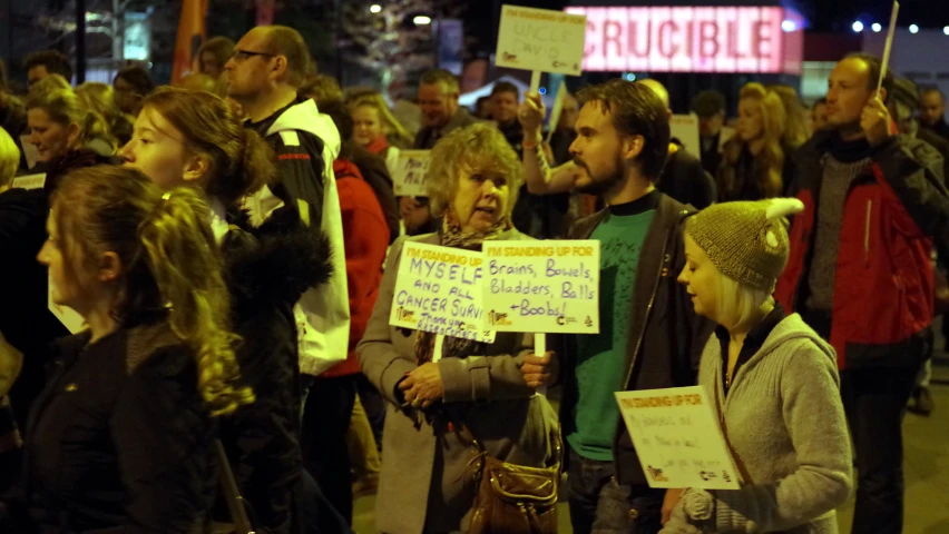 a group of people gather together in protest at a rally