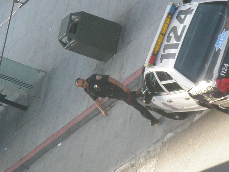 a police officer and a cop stand next to a parked police car