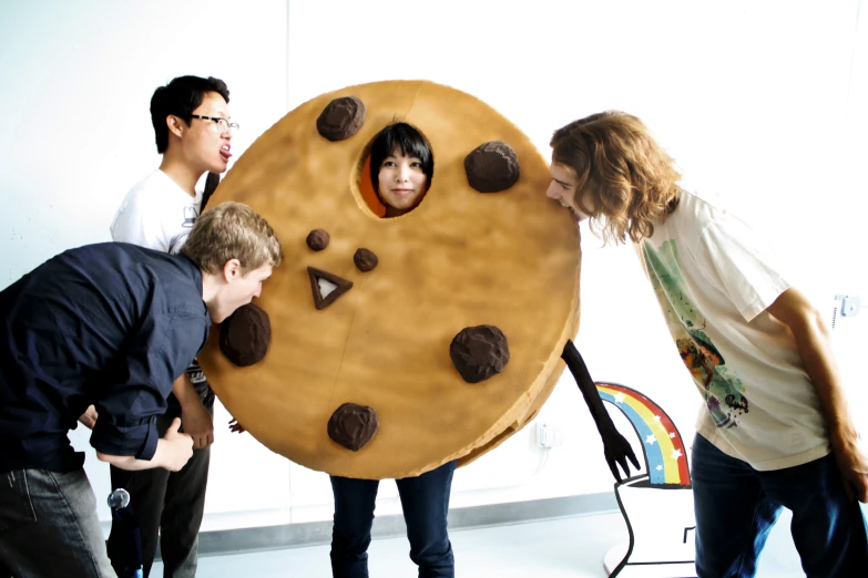 several people looking at a cookie and two have cookies on it