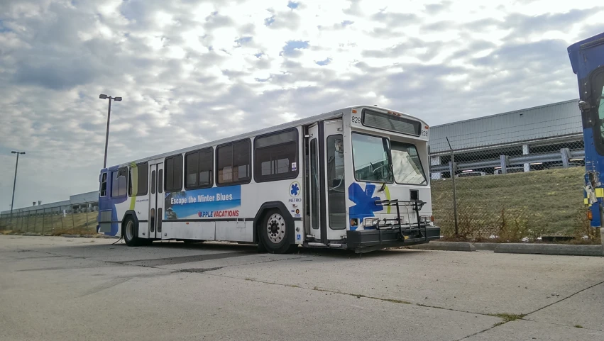 the white bus is parked on the side of the road