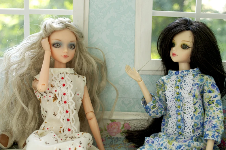 two dolls sit next to each other in a room