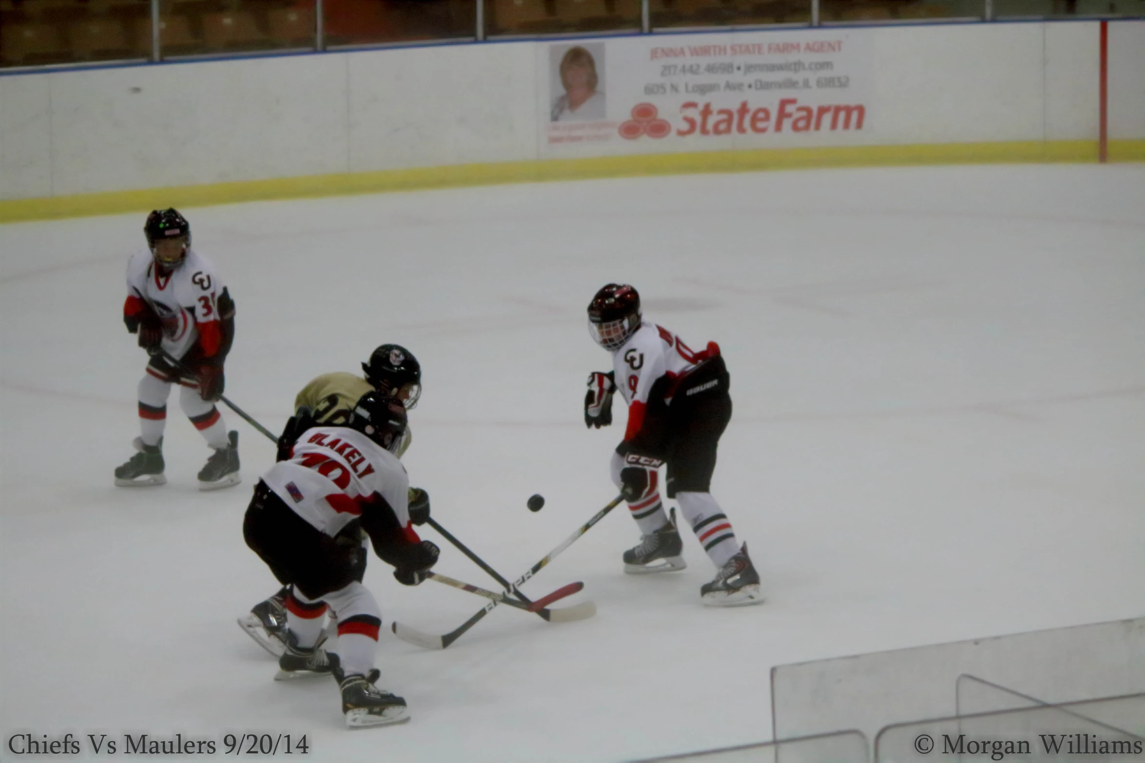 three people in uniform playing a game of ice hockey