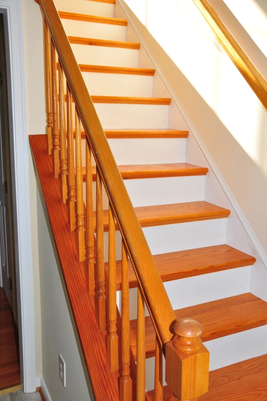 a wooden staircase with wooden handrail and railing