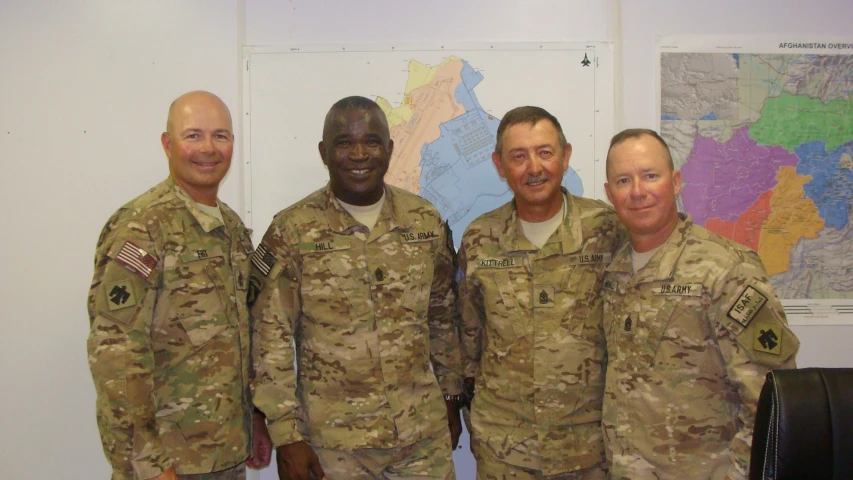 three men dressed in army fatigues and posing for a po