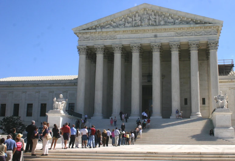 many people standing outside of the supreme court building