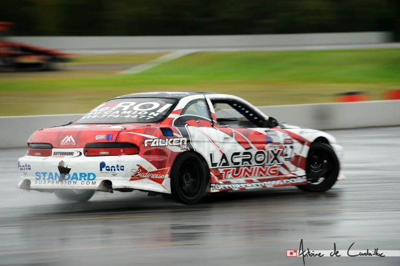 a racing car speeding through a wet race track