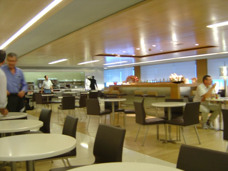 some men walking around in a busy food court