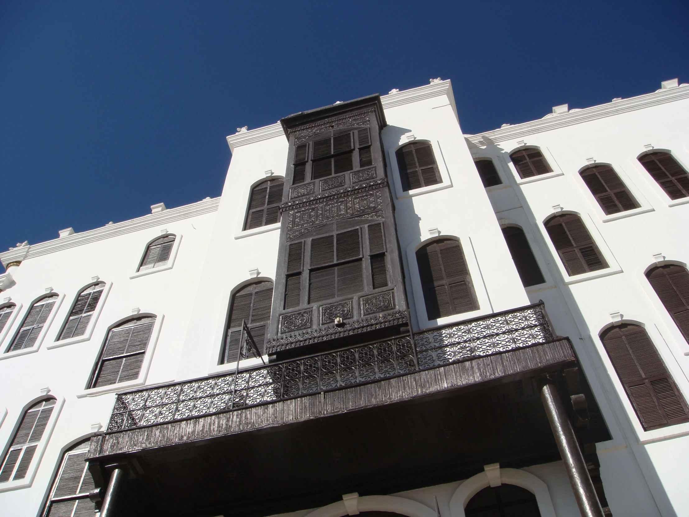 an old white building with balconies and a balcony