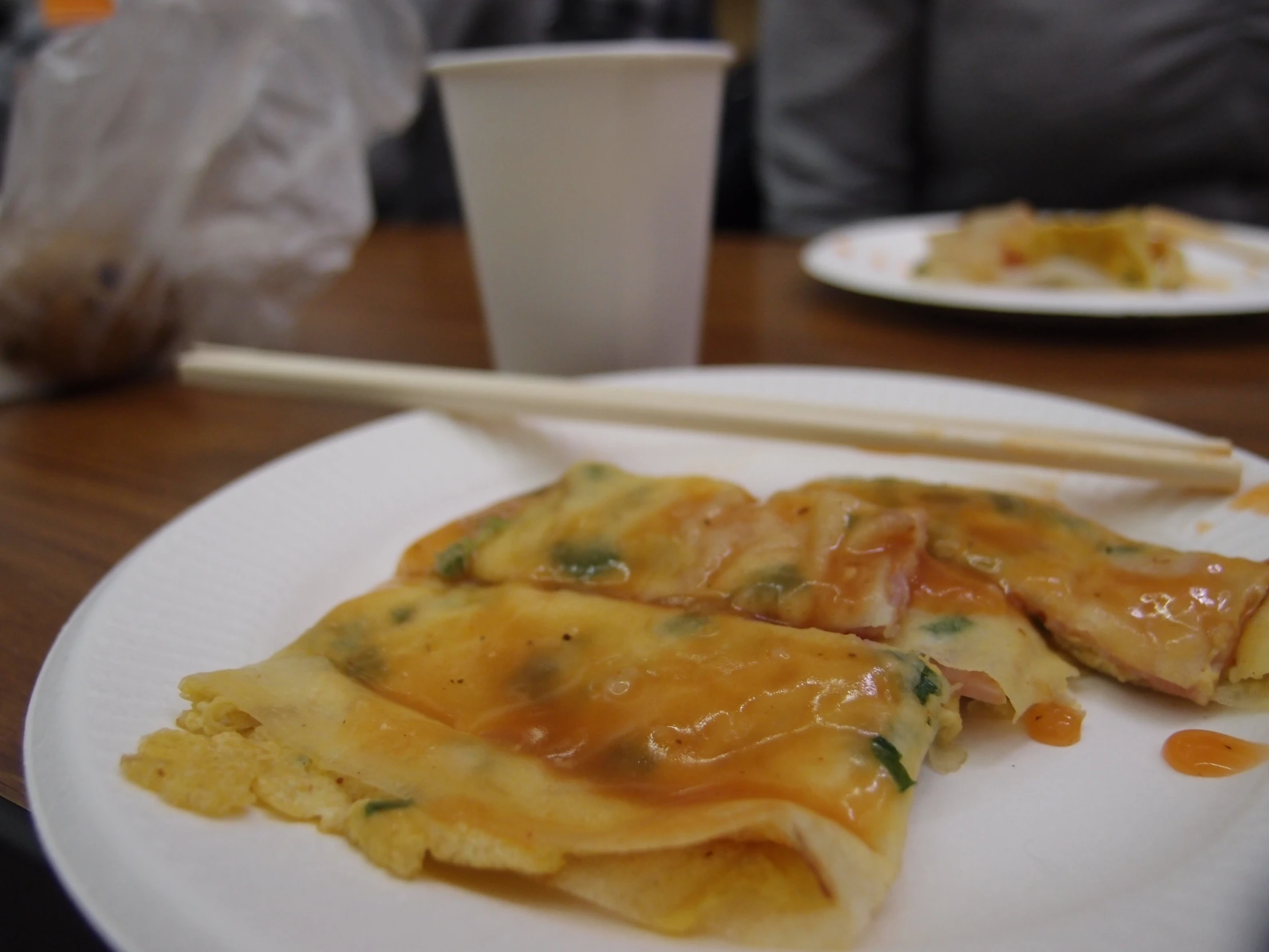 a white plate topped with an egg roll and chopsticks