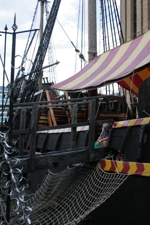 people look out at an old pirate ship that's tied up