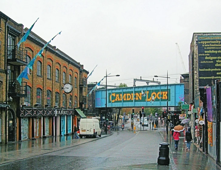 a crowd walking down a street in the rain