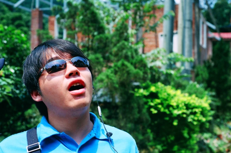 a man wearing sunglasses singing into a microphone