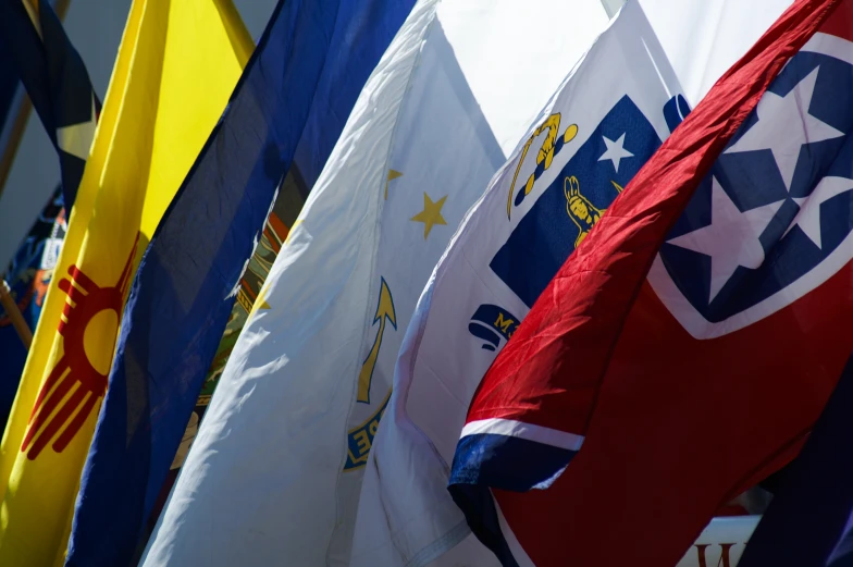 many flags of different countries are standing up in the sun