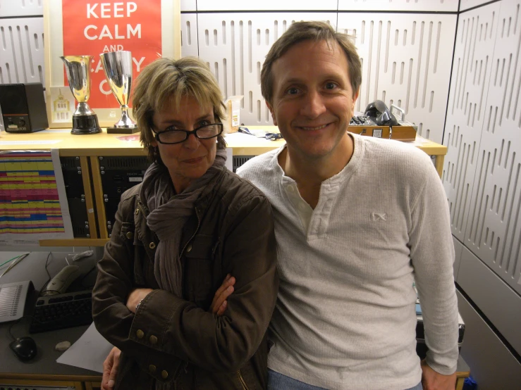 a man and woman standing next to each other in front of a desk