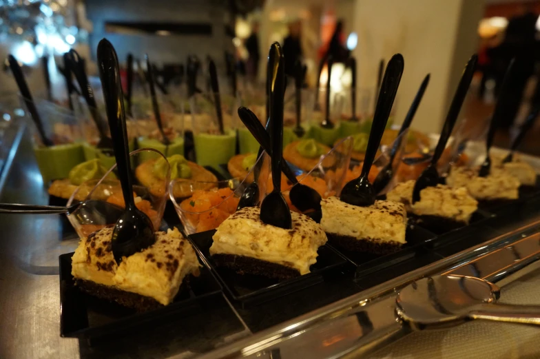 a line of desserts arranged on a tray for serving