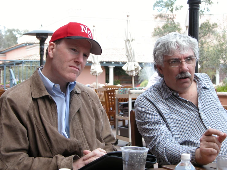 a man in a cap and glasses at a table