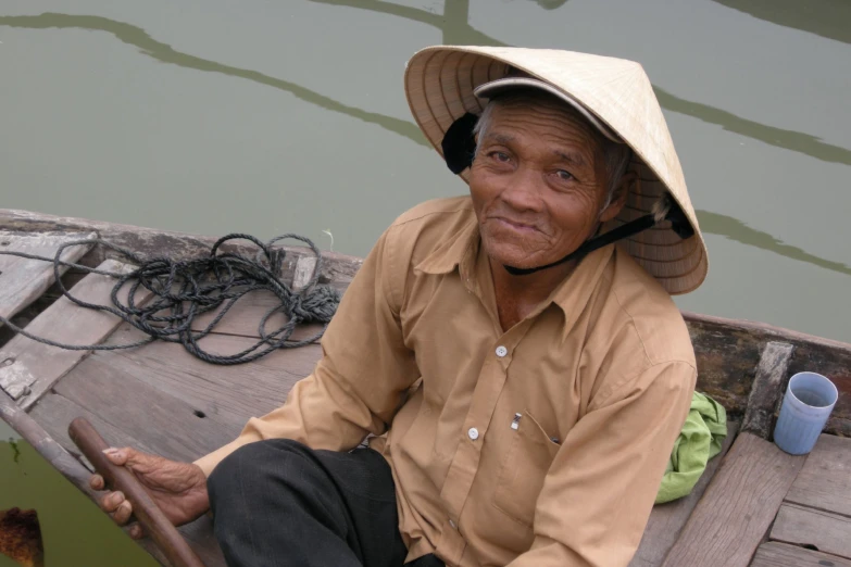 a man wearing a hat and sitting on top of a boat