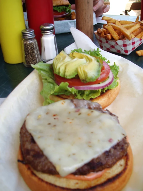 two burgers with cheese on top on paper