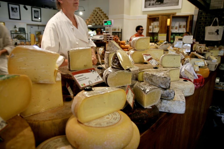 a man standing next to a table full of cheeses