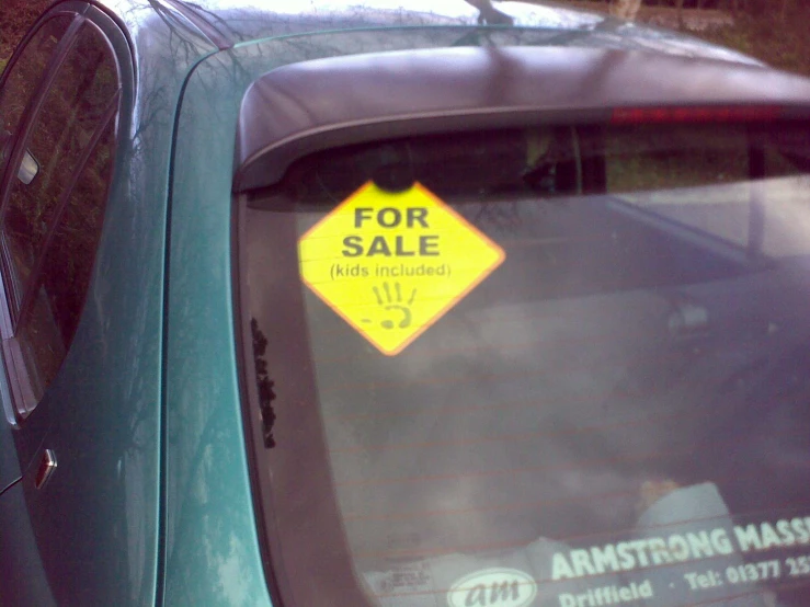 a sticker on the rear window of a car saying for sale
