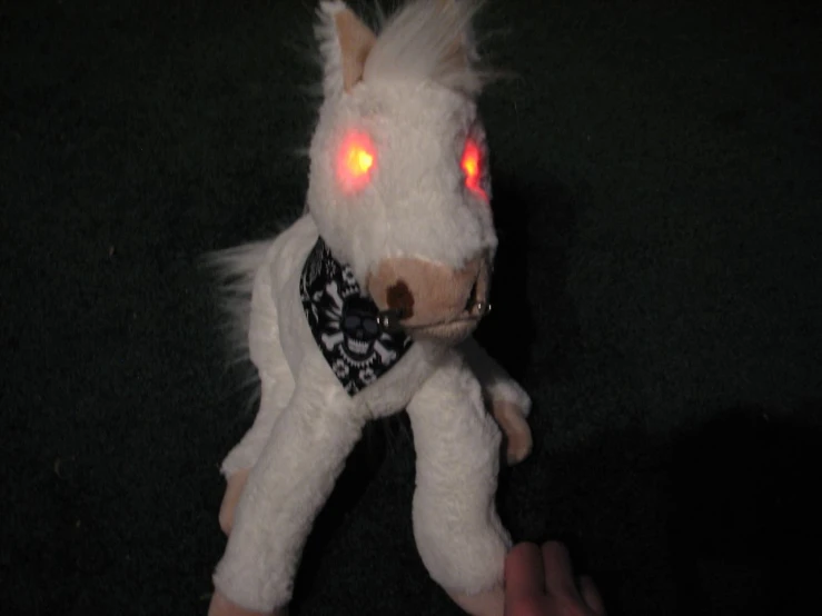 the stuffed animal has glowing red eyes on it