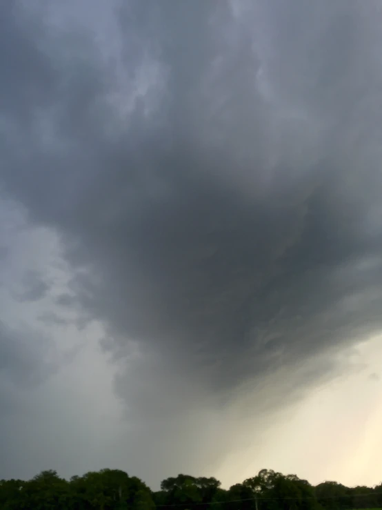 a couple of boats sit in a river under storm clouds