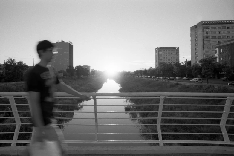 a person stands by a river as the sun is setting