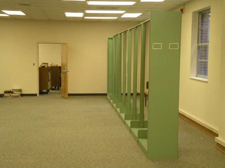 a hallway with green walls and green metal railing