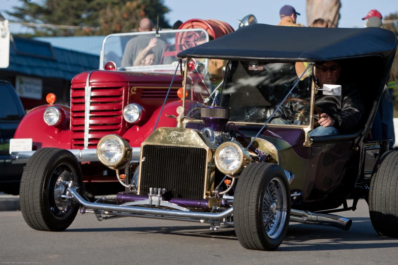 an old fashion car is driving down the road