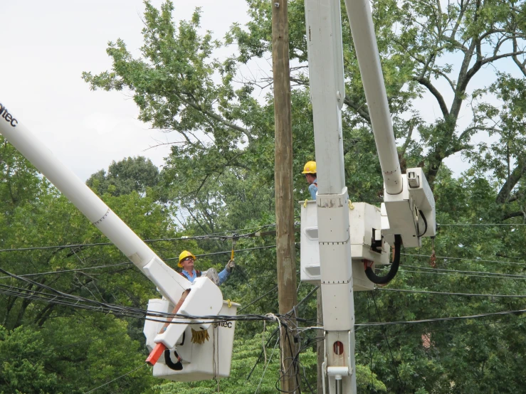 two electric technicians are working on power lines