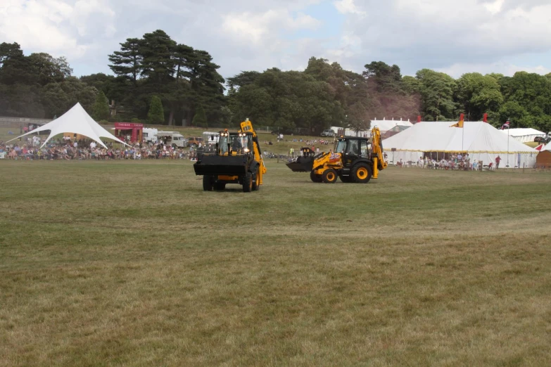 two yellow tractors with some black ones on them