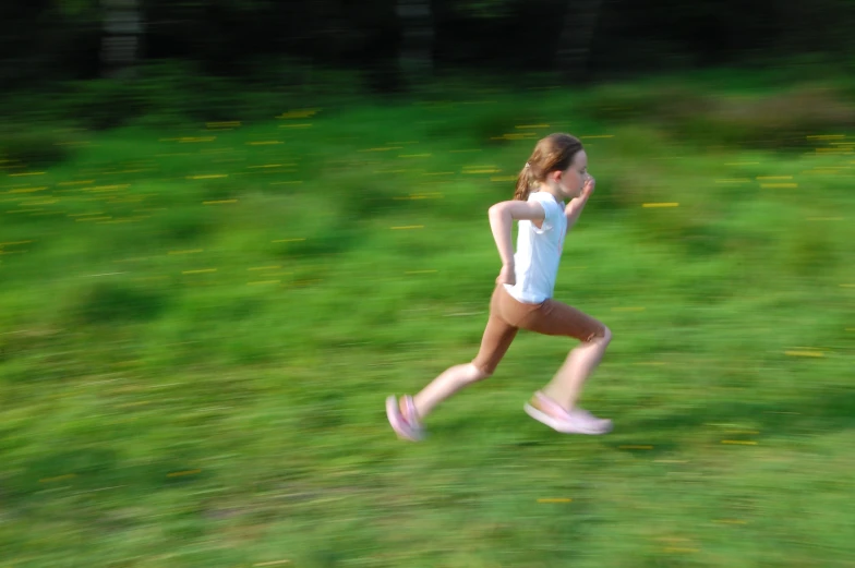 a  in white shirt and white shorts running through grass