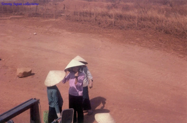 some old women are standing outside on a dirt road