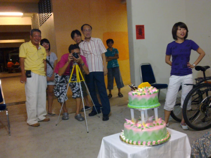 a woman is looking at a cake in the middle