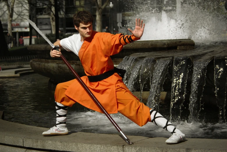 man in an orange costume doing the ninja on his arm