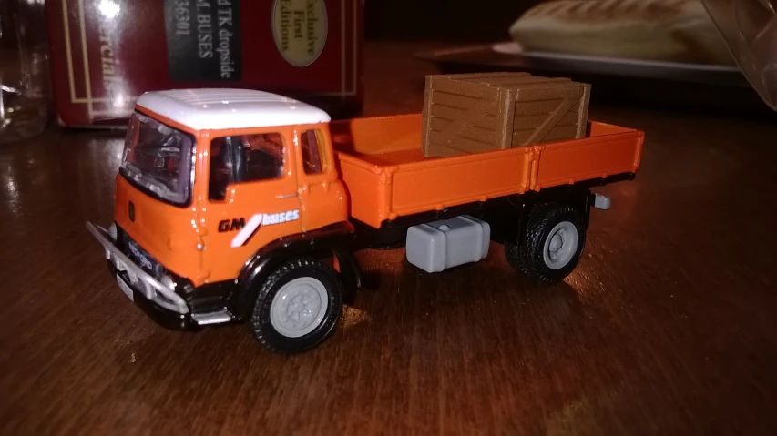 an orange truck with a brown crate on the back