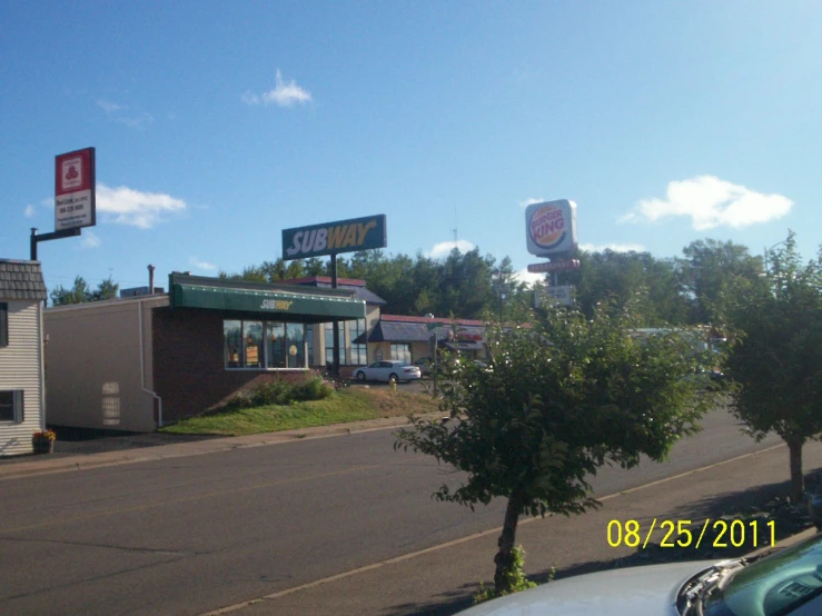 a restaurant on the corner with cars parked outside