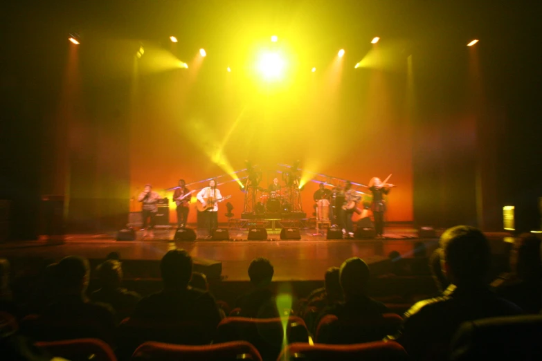 several people on the stage at night with bright lighting